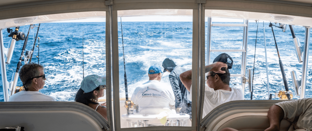 Group of people onboard Chino Salsa's charter boat, out for a fishing trip