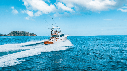 Image of Chino Salsa 37 feet sportfishing boat speeding across bright blue ocean water in Costa Rica, cutting a curved white wake as it heads toward the horizon under a sunny sky.