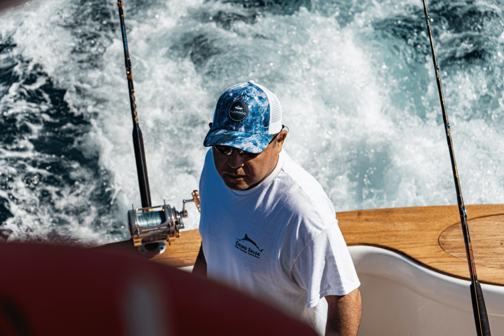 Image of an experienced angler onboard Chino Salsa fishing charter boat wearing white tshirt with Chino Salsa logo