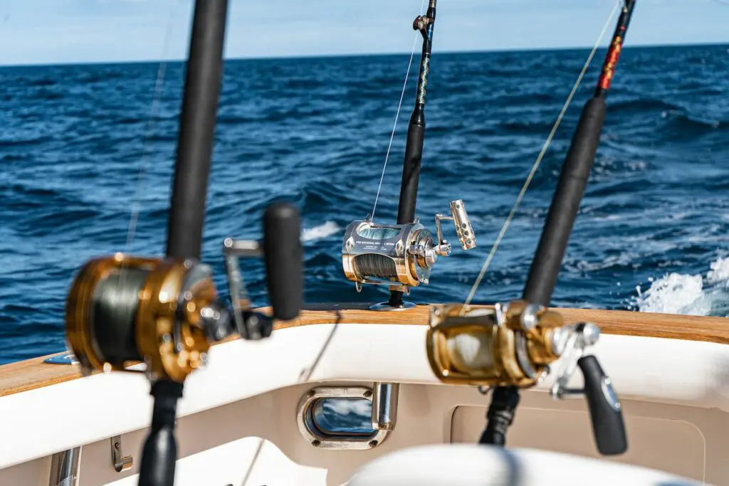 Premium deep sea sportfishing rods and reels mounted on a charter fishing boat in the open ocean